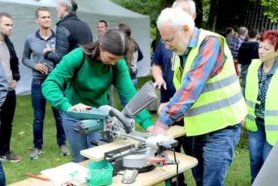 Im Wildbienen-Workshop werden wir handwerklich tätig. Mitarbeiterin an Station im Wildbienen-Workshop
