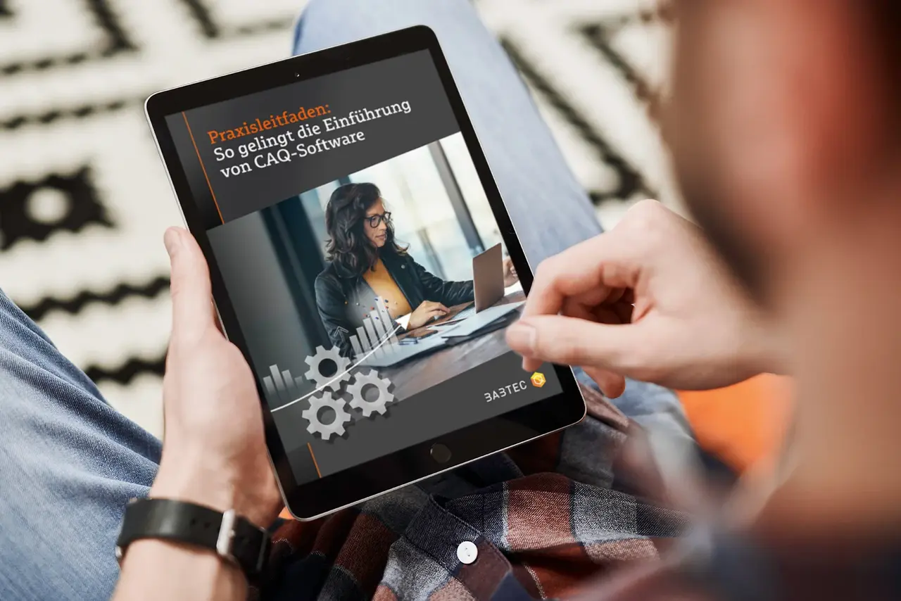 Das CAQ-Whitepaper von Babtec Ein Mann liest das CAQ-Whitepaper auf einem iPad