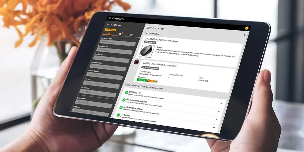 Zwei Hände, die ein Tablet in der Hand halten; darauf zu sehen das Reklamationsmanagement in BabtecQ Go