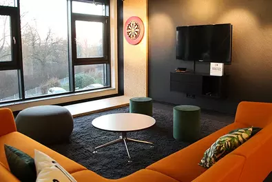 Schöner arbeiten bei Babtec Neugestalteter Arbeitsraum mit orangefarbenem Sofa