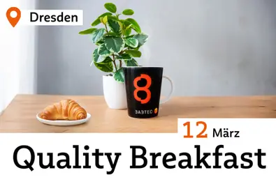 Tisch mit Croissant, Kaffebecher und Pflanze