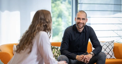 Babtec-Mitarbeitende sitzen auf dem Sofa im Büro und unterhalten sich
