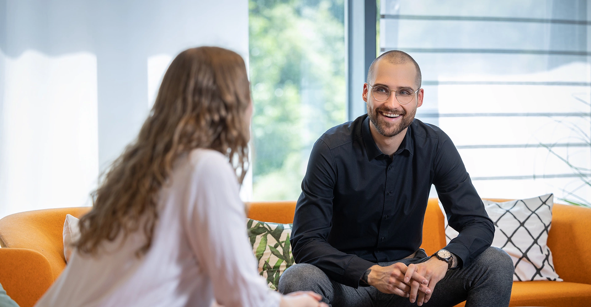 Babtec-Mitarbeitende sitzen auf dem Sofa im Büro und unterhalten sich