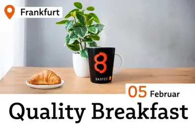 Tisch mit Croissant, Kaffebecher und Pflanze