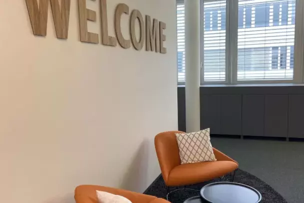 Entrance area of the Munich office Two orange-coloured armchairs adorn the entrance area of the new office