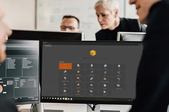 Mitarbeiter an einem Arbeitsplatz, auf dem Desktop ist BabtecQ zu sehen