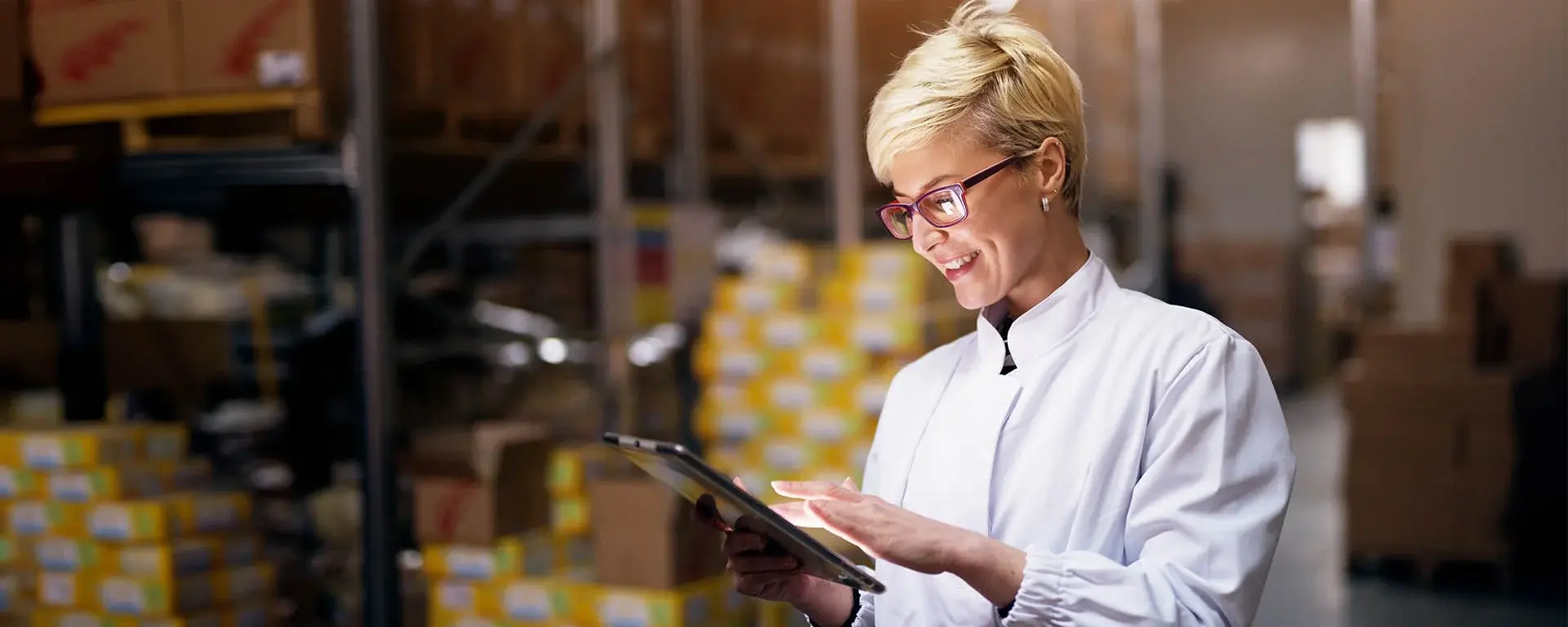 Eine lächelnde Frau arbeitet in einem Unternehmen am Tablet